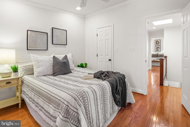 bedroom featuring crown molding, ceiling fan, and wood-type flooring