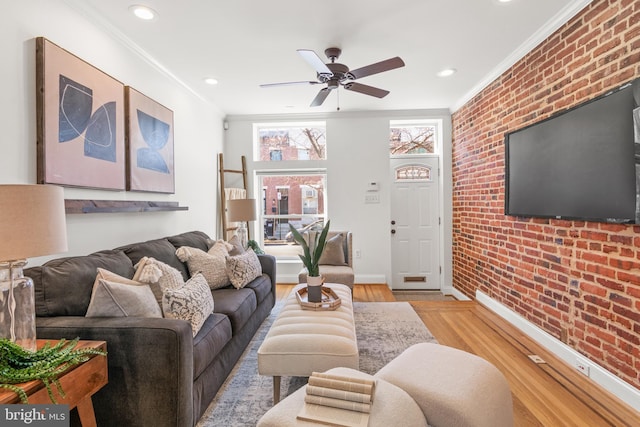 living room featuring ornamental molding, brick wall, ceiling fan, and light hardwood / wood-style floors