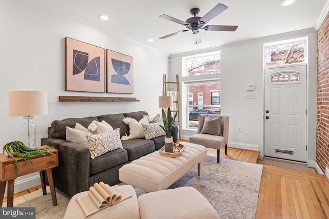 living room with crown molding, ceiling fan, brick wall, and light hardwood / wood-style flooring