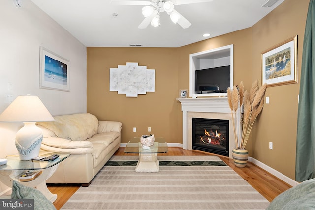 living room with ceiling fan and light hardwood / wood-style flooring