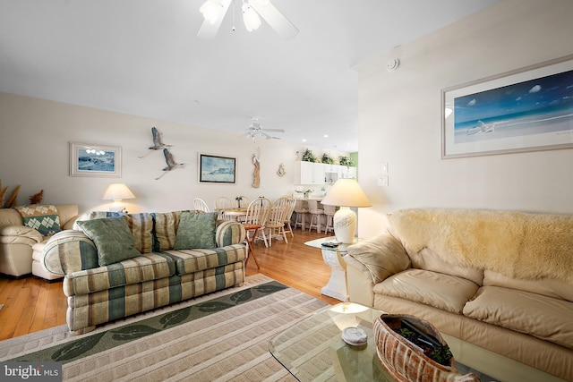 living room featuring ceiling fan and light hardwood / wood-style flooring