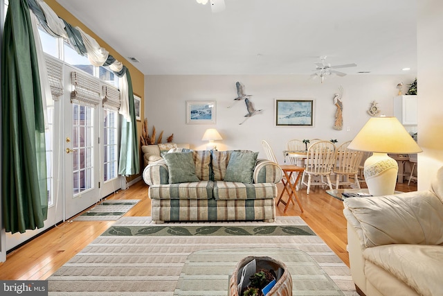 living room with ceiling fan, light wood-type flooring, and french doors