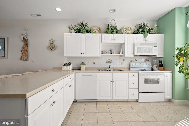 kitchen featuring white cabinetry, sink, light tile patterned flooring, and white appliances