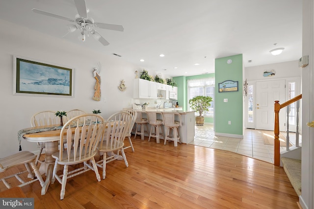 dining space featuring ceiling fan and light wood-type flooring