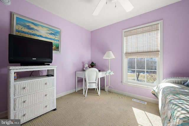 carpeted bedroom featuring multiple windows and ceiling fan