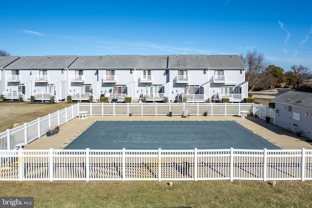 back of house featuring a covered pool and a yard