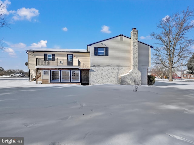 view of snow covered rear of property