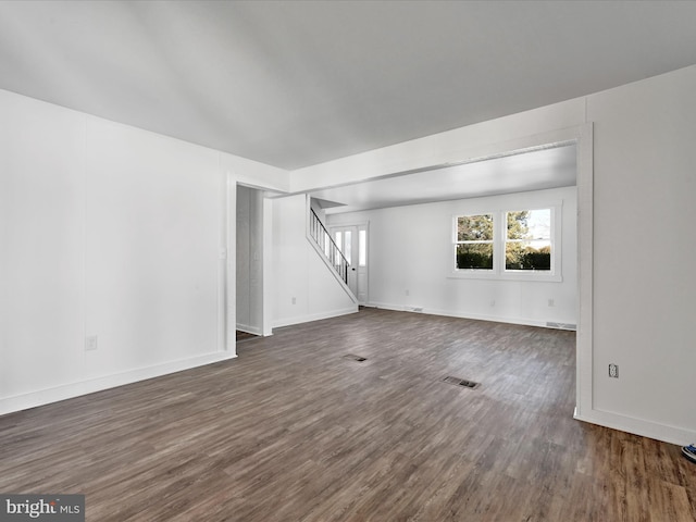 unfurnished living room with dark wood-type flooring