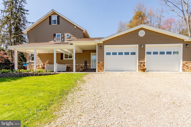 view of front of home with a garage, a front yard, and a porch