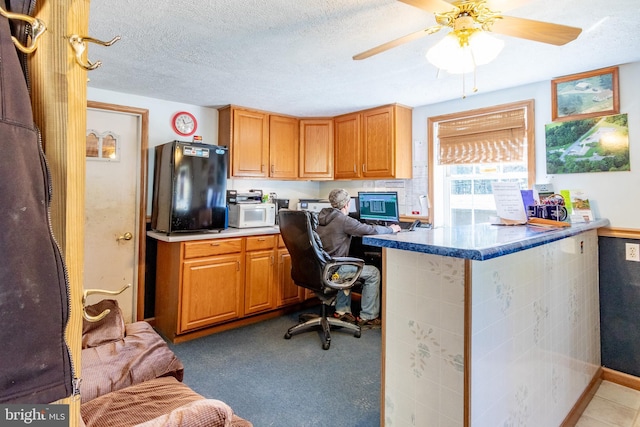 home office with ceiling fan and a textured ceiling