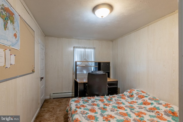 bedroom with a baseboard heating unit, wood walls, a textured ceiling, and carpet