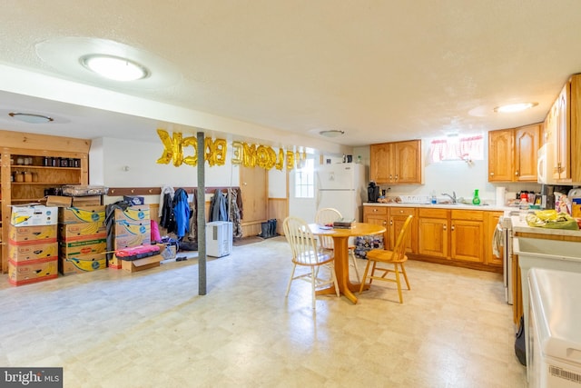 kitchen featuring sink, stainless steel stove, and white fridge