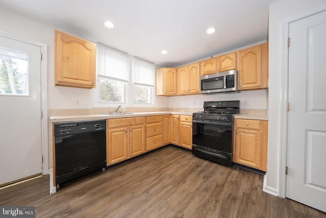 kitchen with plenty of natural light, dark hardwood / wood-style floors, light brown cabinets, and black appliances