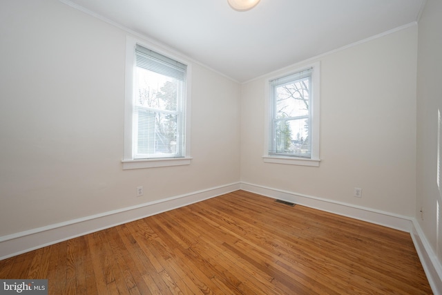 unfurnished room featuring ornamental molding and wood-type flooring