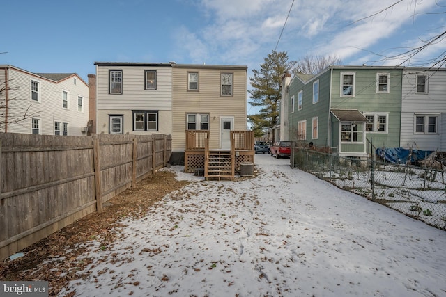 snow covered house featuring a deck