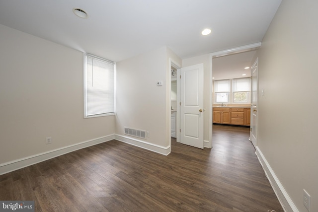 spare room with dark wood-type flooring and sink