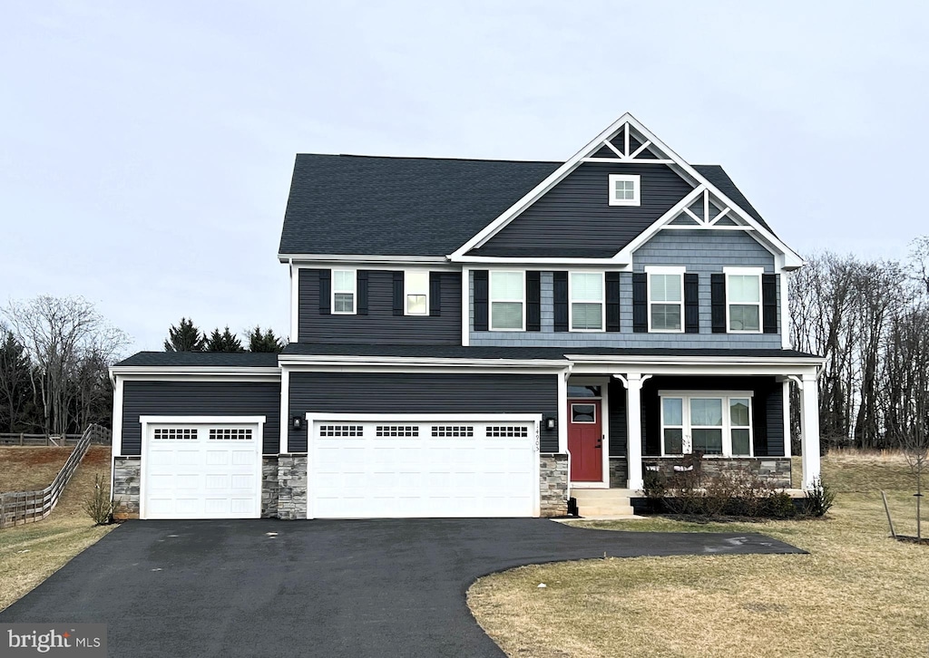 craftsman-style home featuring covered porch and a front lawn