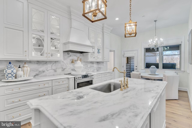 kitchen featuring sink, stainless steel electric range, white cabinetry, decorative light fixtures, and custom exhaust hood