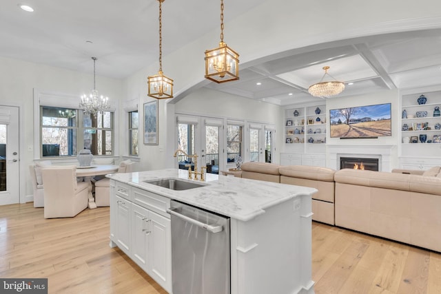 kitchen with white cabinetry, decorative light fixtures, an island with sink, and dishwasher