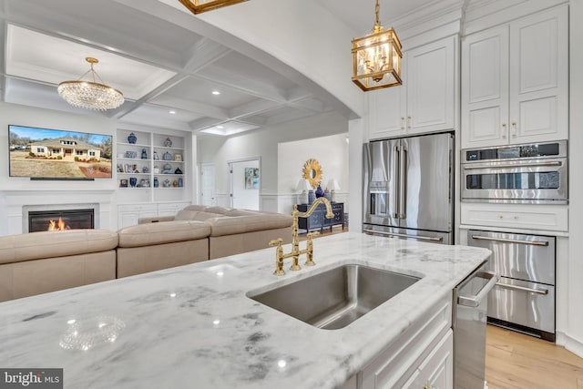 kitchen featuring light stone counters, hanging light fixtures, and appliances with stainless steel finishes