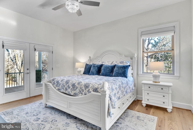 bedroom featuring multiple windows, access to outside, french doors, and light wood-type flooring