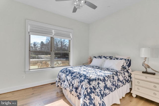 bedroom with multiple windows, ceiling fan, and light wood-type flooring