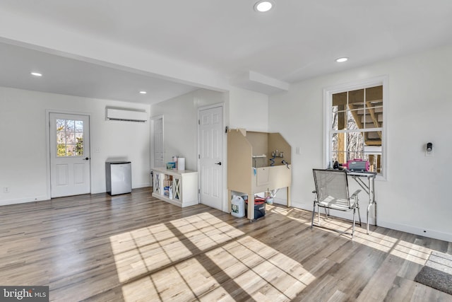 unfurnished living room featuring wood-type flooring and a wall mounted AC