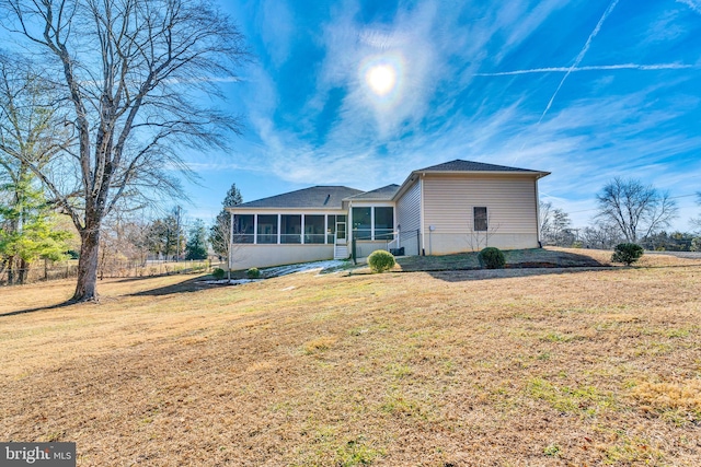 exterior space with a sunroom and a lawn