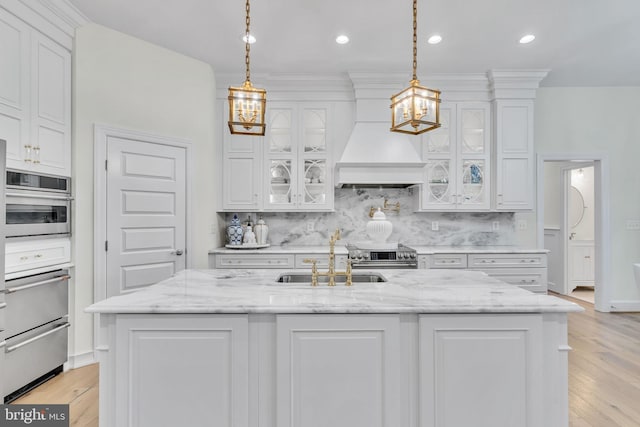 kitchen featuring pendant lighting, light stone countertops, stainless steel range with electric cooktop, and white cabinets