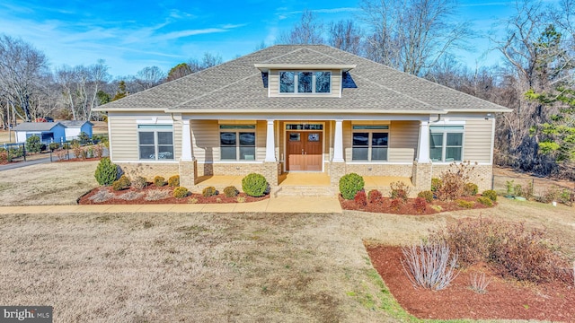 view of front of house with a front yard and a porch