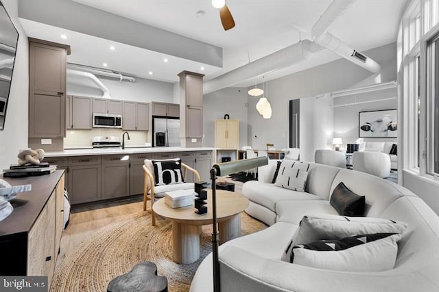 living room featuring ceiling fan and light wood-type flooring