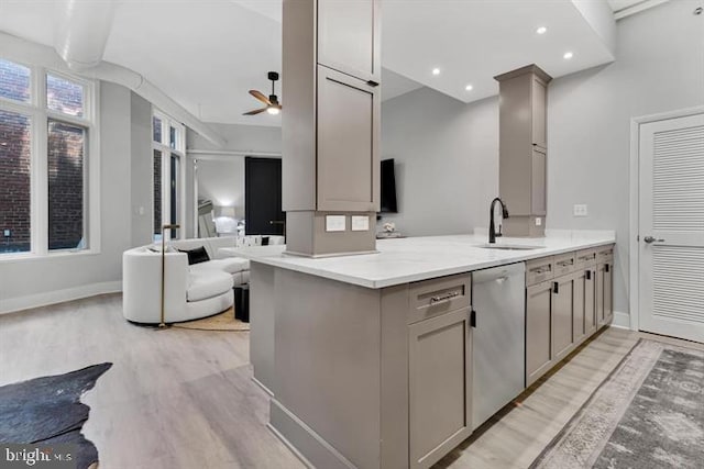 kitchen with gray cabinets, dishwasher, sink, light hardwood / wood-style floors, and kitchen peninsula