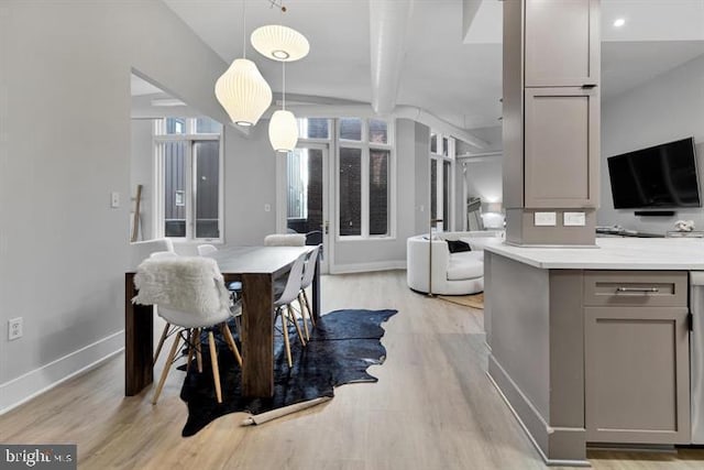 dining room with beamed ceiling and light hardwood / wood-style flooring