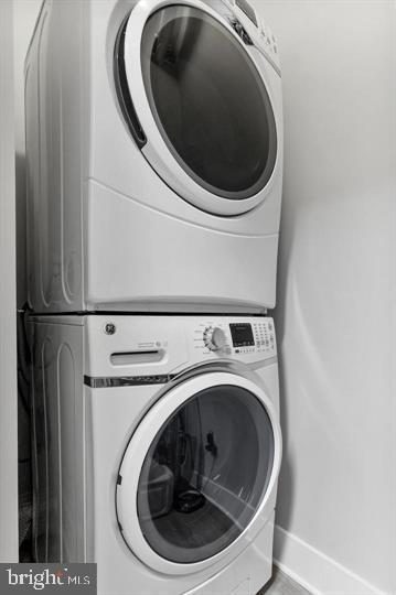 clothes washing area with stacked washer and dryer