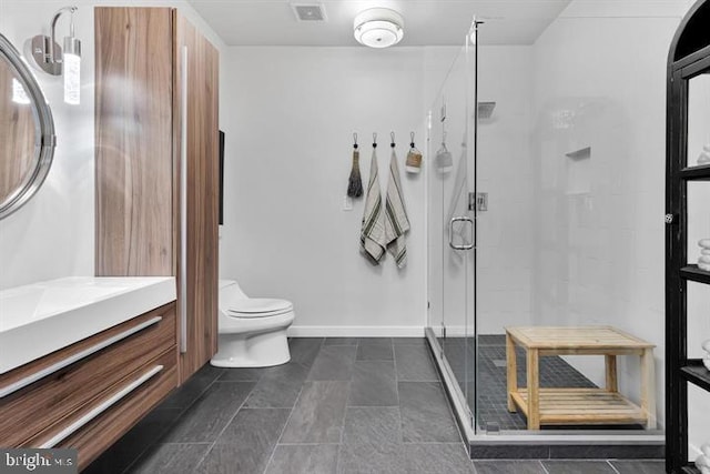 bathroom with vanity, toilet, and a shower with shower door