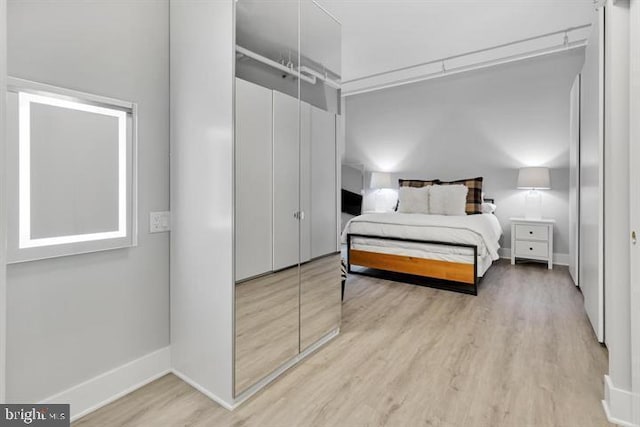 bedroom with light hardwood / wood-style flooring and a closet