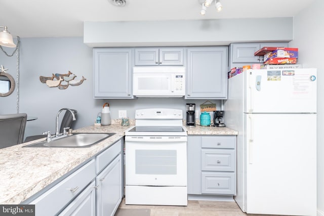 kitchen featuring sink, white appliances, and light hardwood / wood-style flooring