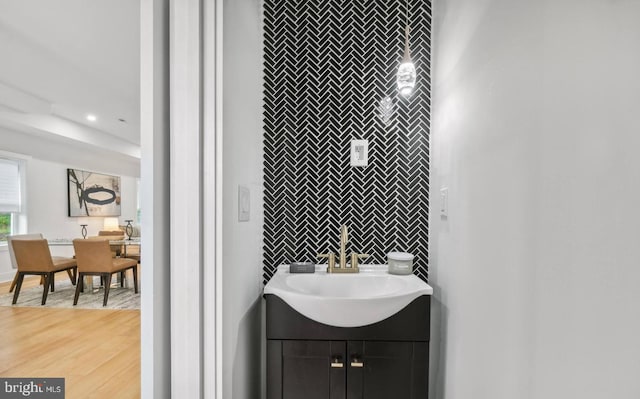 bathroom with tile walls, hardwood / wood-style floors, and sink