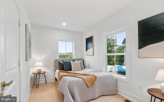 bedroom featuring multiple windows and light wood-type flooring