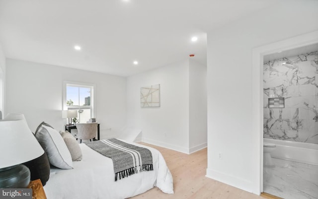 bedroom featuring ensuite bath and light wood-type flooring