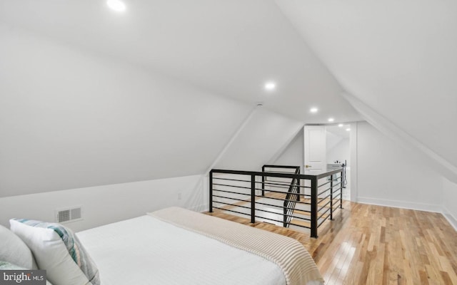 bedroom featuring lofted ceiling and light hardwood / wood-style flooring