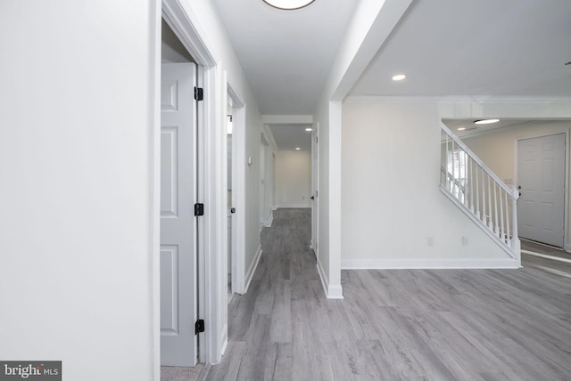 corridor with crown molding and light hardwood / wood-style floors