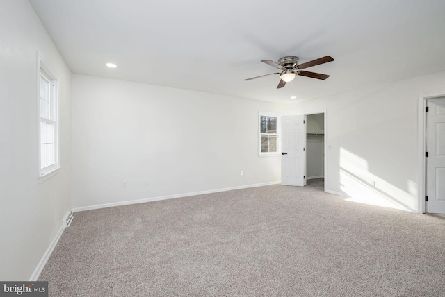 carpeted empty room featuring a wealth of natural light and ceiling fan