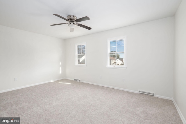 carpeted spare room featuring ceiling fan