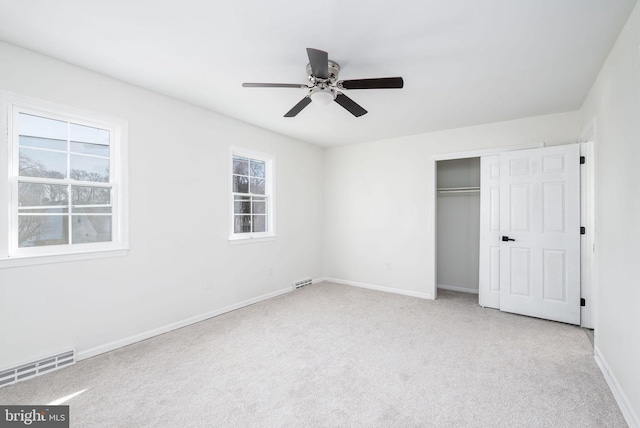 unfurnished bedroom featuring light carpet, ceiling fan, and a closet