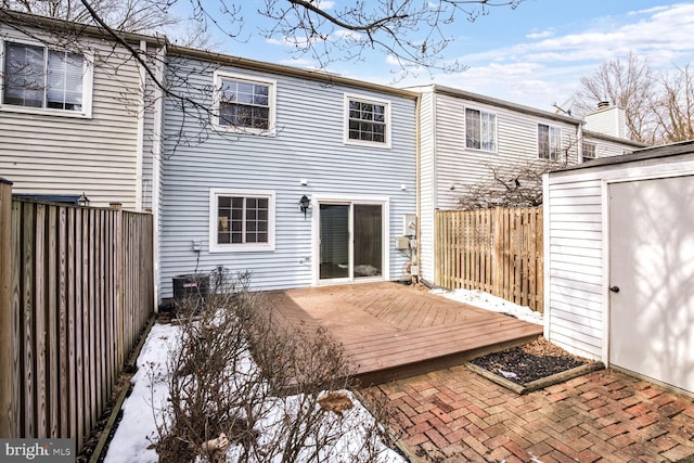 back of house with a deck and a shed