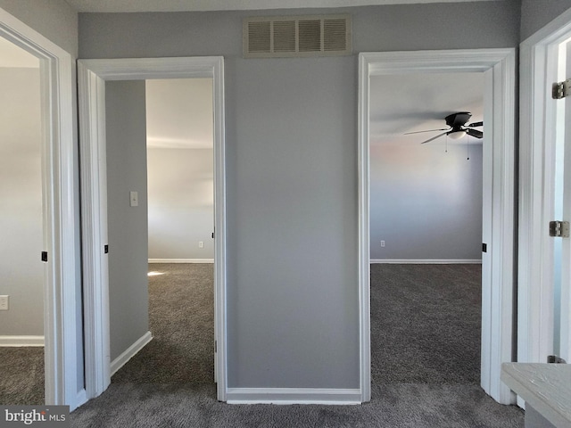 hall with dark colored carpet