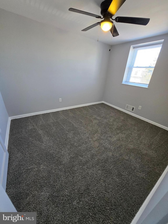 carpeted spare room featuring ceiling fan