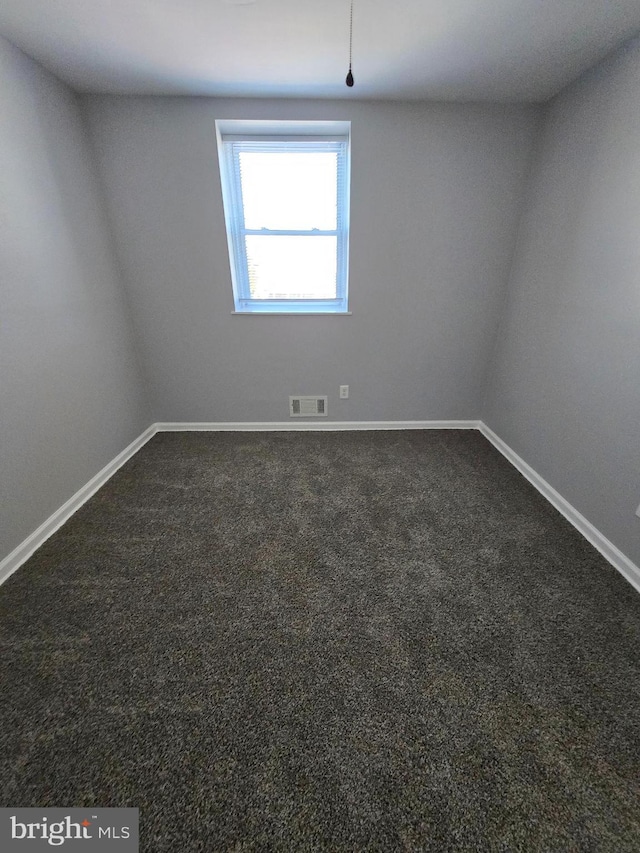 empty room featuring dark colored carpet