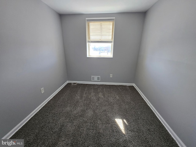 empty room with dark colored carpet